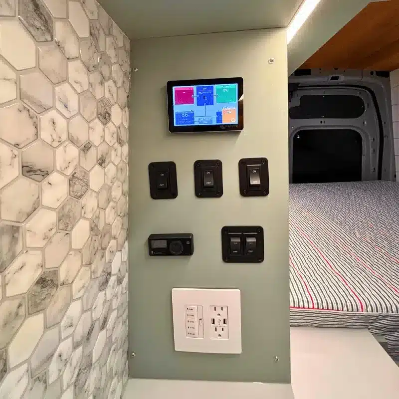 Steuerungspanel mit Schaltern, USB- und 110V-Steckdosen im Innenraum eines Ford Transit Bon Echo Campervans