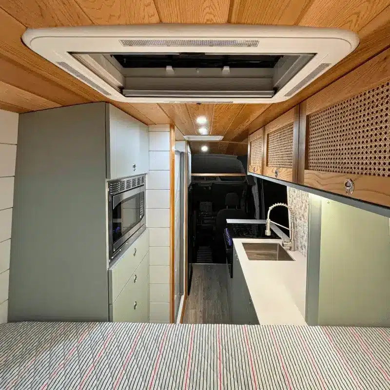 Innenansicht des Ford Transit Bon Echo Campervan mit Küchenzeile, Spüle, Mikrowelle und Stauraum