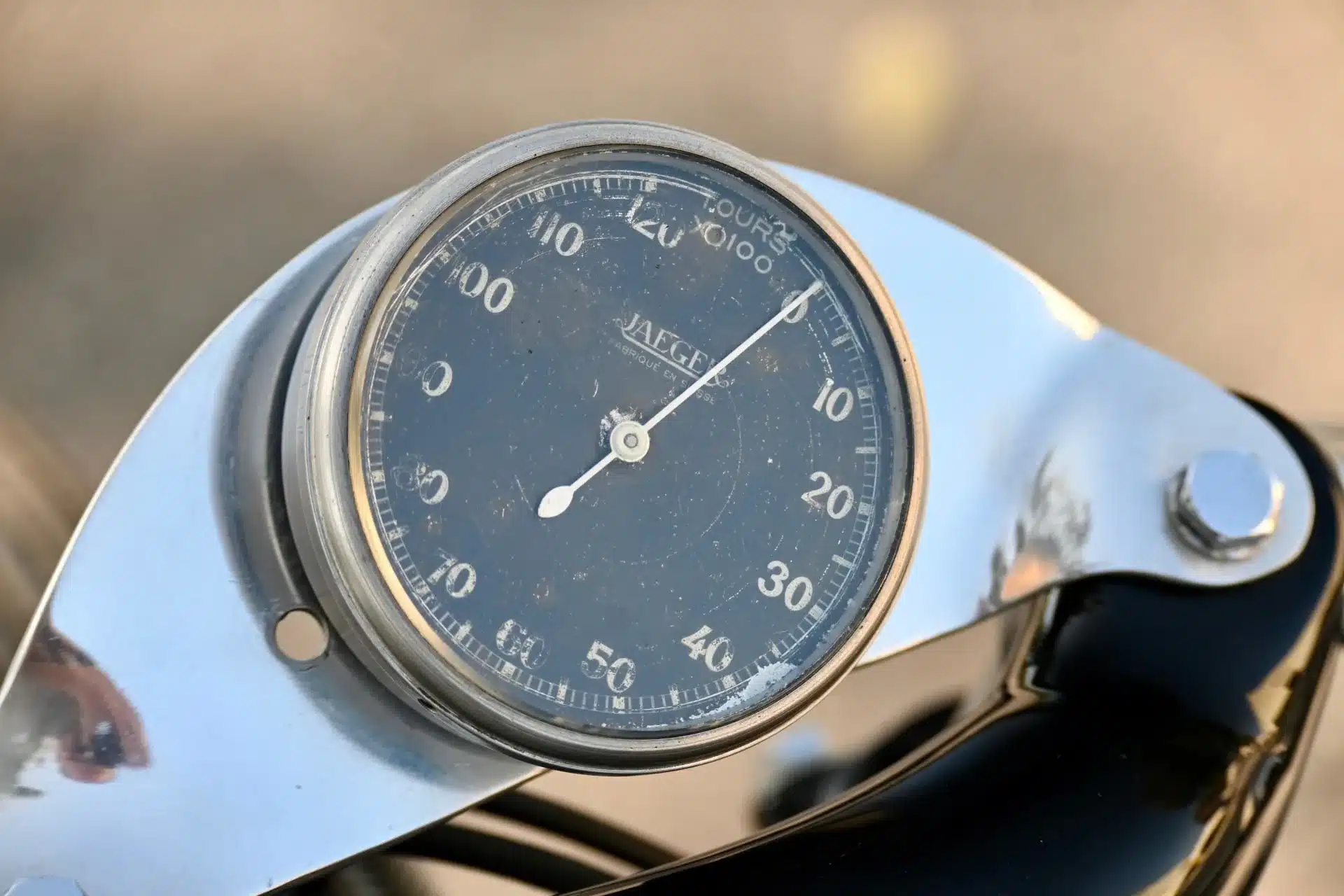 Nahaufnahme eines analogen Jaeger-Drehzahlmessers an einem 1957er Rennmotorrad mit Chromhalterung.