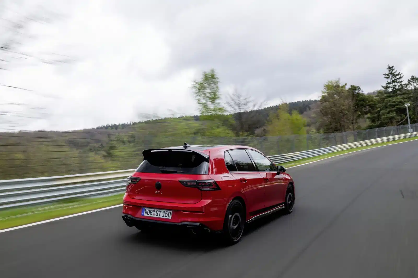 Roter Golf GTI Edition 50 fährt auf der Nordschleife, Seiten- und Heckansicht
