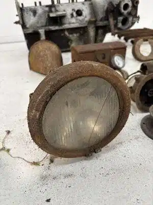Alter, rostiger Motorrad-Scheinwerfer mit Teilen des Henderson De Luxe Motors im Hintergrund