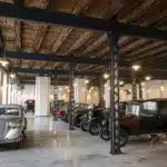 Ausstellung historischer Škoda-Fahrzeuge im Originalzustand in einer restaurierten Fabrikhalle mit sichtbaren Stahlträgern und Holzbalkendecke