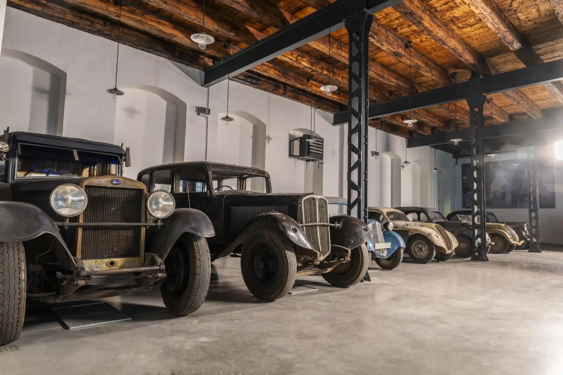 Reihe historischer Škoda-Automobile im unrestaurierten Zustand in einer alten Werkshalle