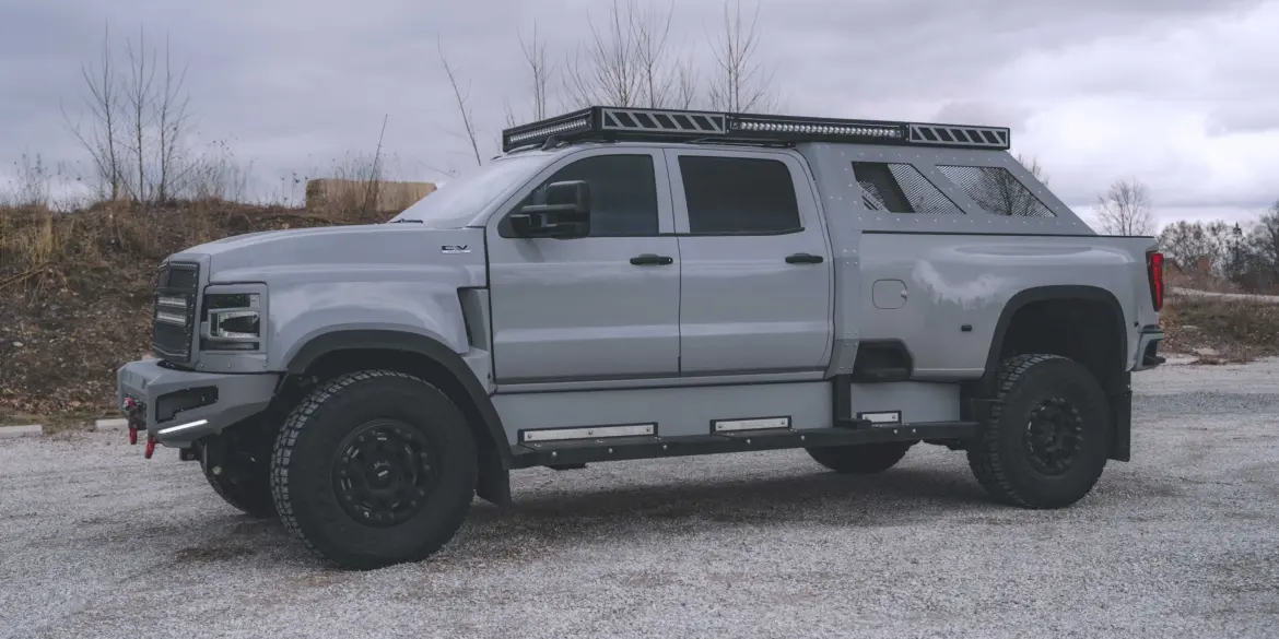 2020 International CV515 Pickup in Nardo-Grau mit Expeditionsausstattung, großen Offroad-Reifen und robusten Anbauteilen auf einem Kiesplatz.