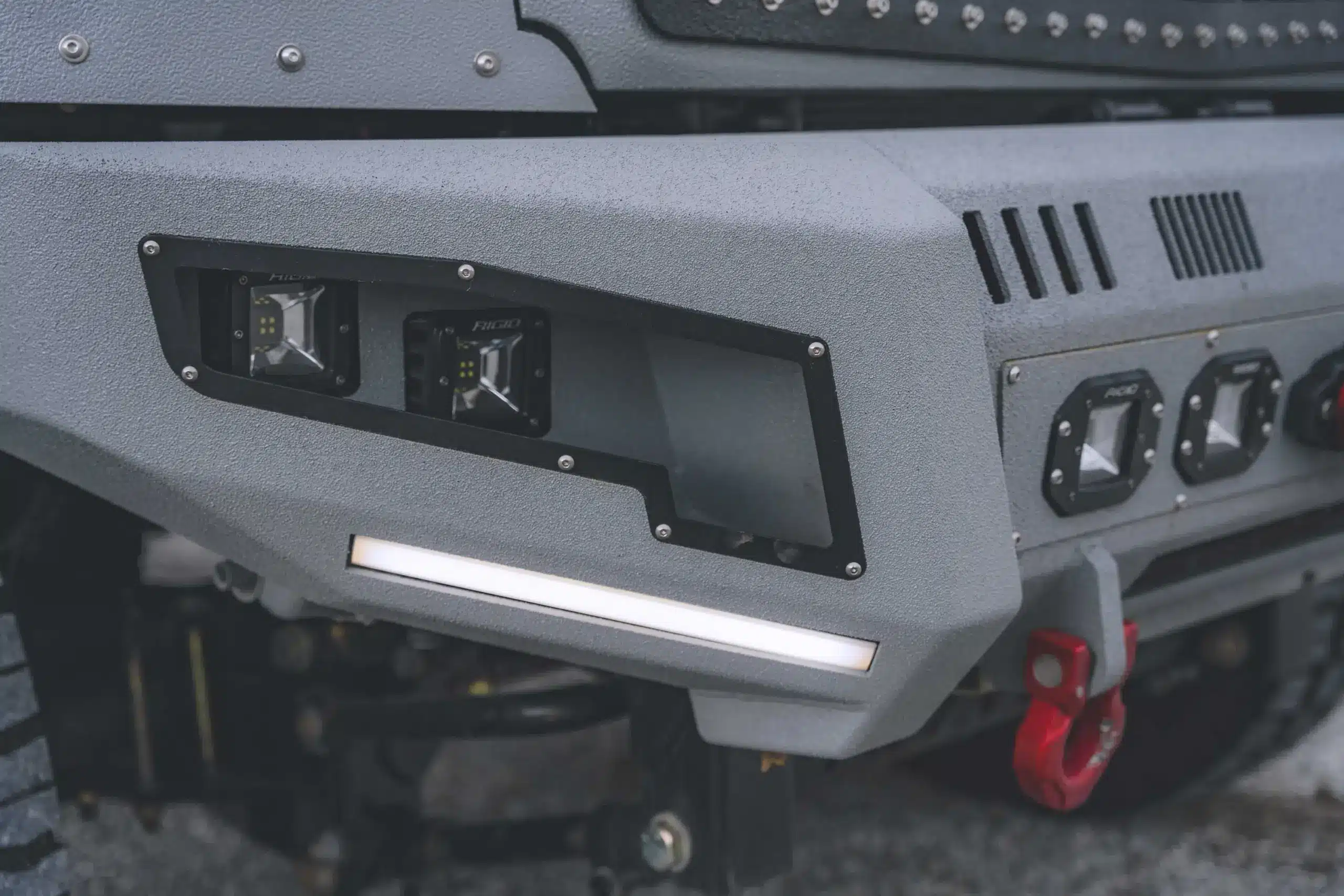 Detailansicht der robusten Frontstoßstange mit LED-Arbeitsleuchten und roten Bergehaken am 2020 International CV515.