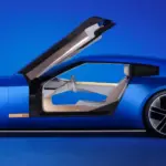 Seitenansicht des Jaguar Type 00 Konzeptautos in Blau mit geöffneter Gullwing-Tür und futuristischem Interieur.