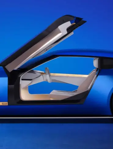 Seitenansicht des Jaguar Type 00 Konzeptautos in Blau mit geöffneter Gullwing-Tür und futuristischem Interieur.