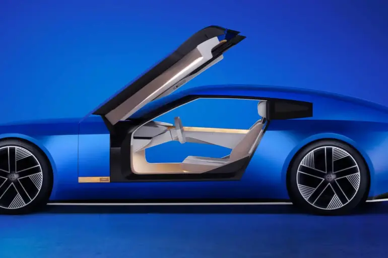 Seitenansicht des Jaguar Type 00 Konzeptautos in Blau mit geöffneter Gullwing-Tür und futuristischem Interieur.