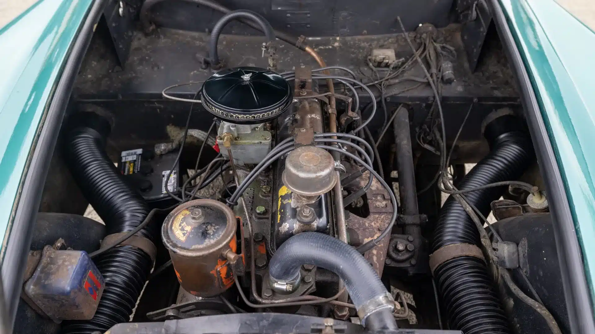 Motorraum eines klassischen Kaiser Darrin 1954 mit authentischer Technik und Alterungsspuren.