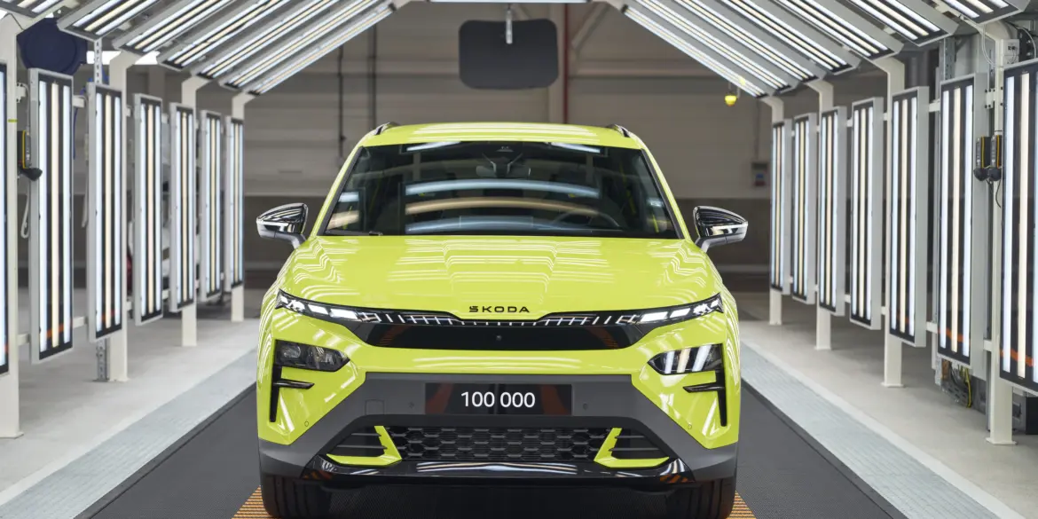 Frontansicht eines Škoda Elroq RS in Mamba Green im Werk unter Fertigungslichtern, Kennzeichen mit 100.000