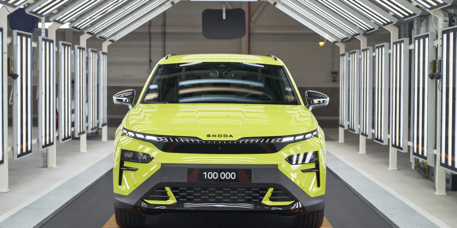 Frontansicht eines Škoda Elroq RS in Mamba Green im Werk unter Fertigungslichtern, Kennzeichen mit 100.000