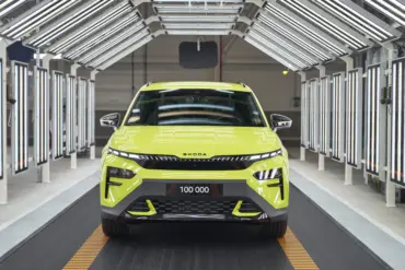 Frontansicht eines Škoda Elroq RS in Mamba Green im Werk unter Fertigungslichtern, Kennzeichen mit 100.000