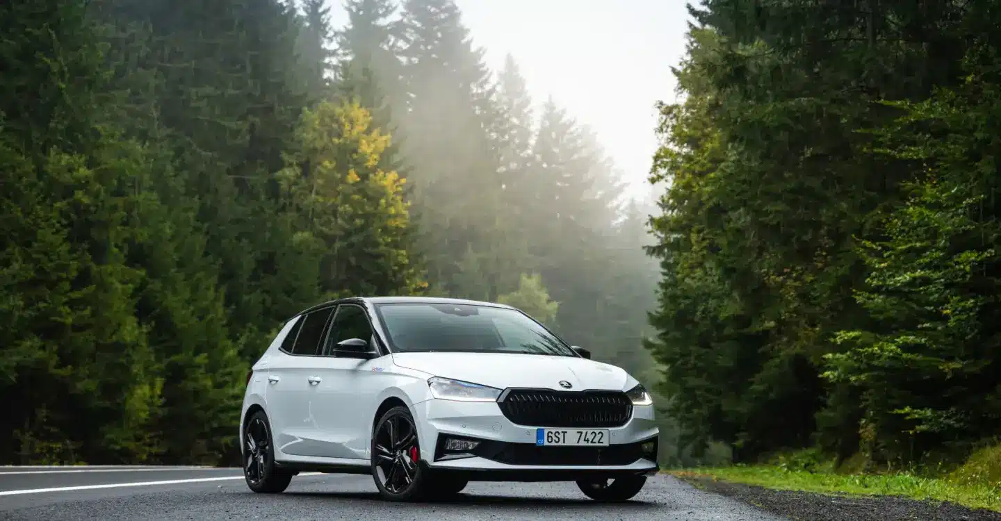 Weißer Škoda Fabia 130 Sondermodell mit schwarzen Akzenten auf einer Landstraße im Wald