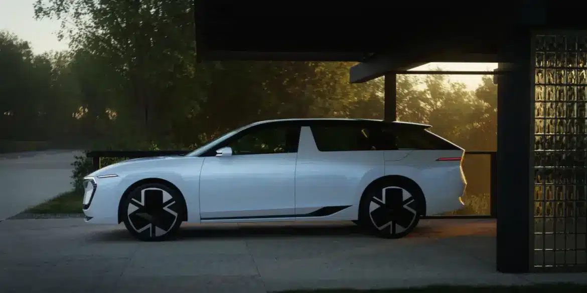 Weißer Škoda Vision O Elektro-Kombi steht seitlich unter einem Carport bei Sonnenuntergang.