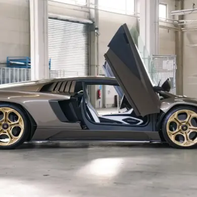 Lamborghini Countach LPI 800-4 in Luci del Bosco, Seitenansicht mit geöffneten Scherentüren und bronzenen Felgen in einer Werkstatthalle.