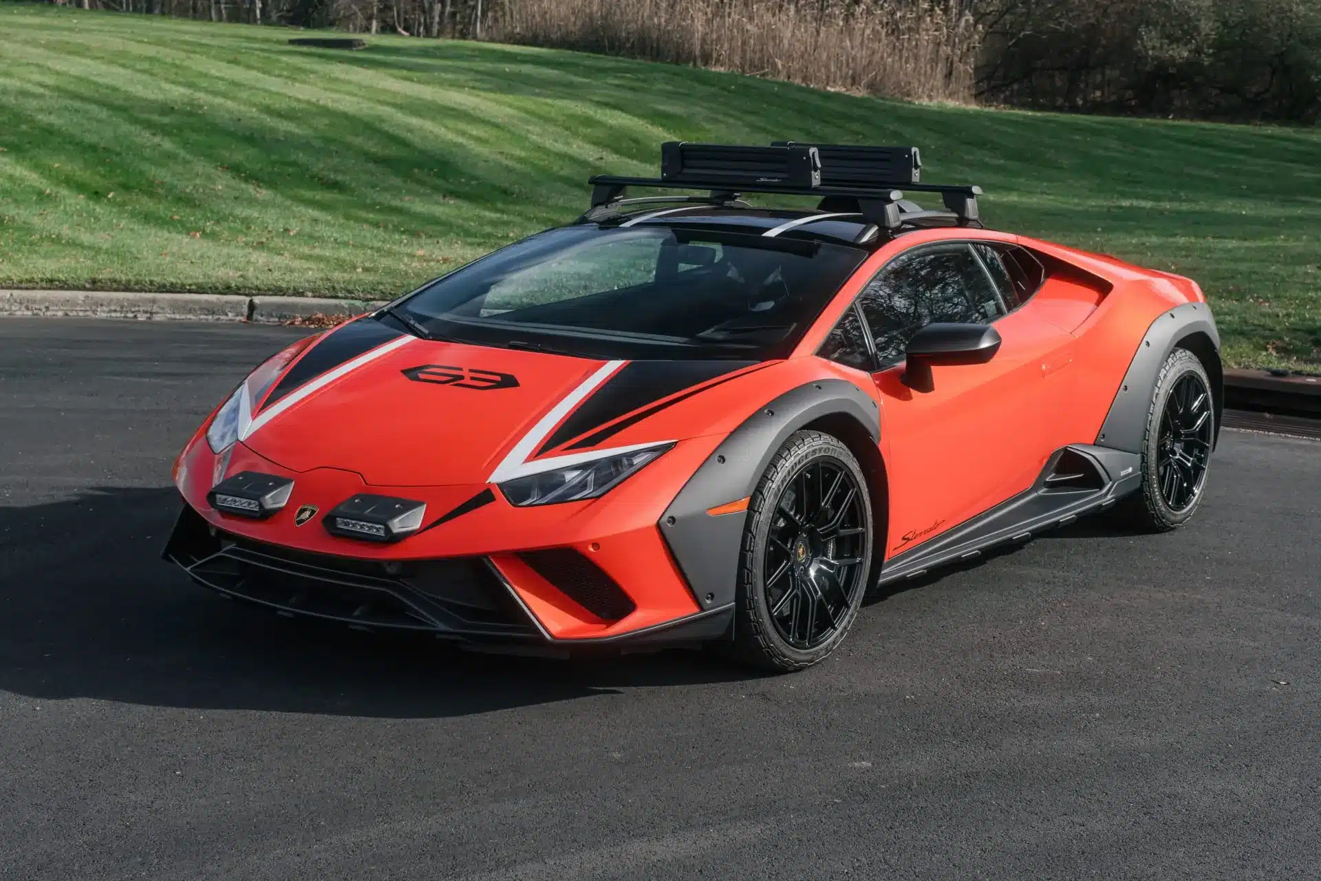 Frontansicht eines roten Lamborghini Huracán Sterrato, ein Supersportwagen mit Offroad-Elementen, auf einer Straße.