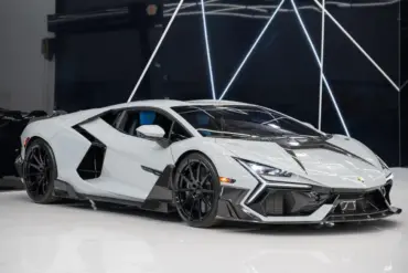 Weißer Lamborghini Revuelto Mansory 2025 mit zahlreichen Carbon-Details in einem modernen Showroom.