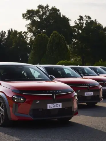 Mehrere Lancia Ypsilon HF in Rot-Schwarz stehen nebeneinander auf einer Straße vor Bäumen.
