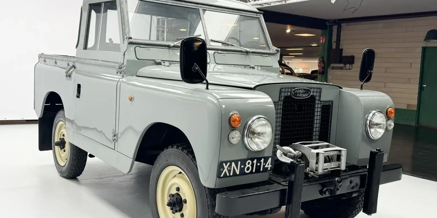 Restaurierter Land Rover Series II Baujahr 1968 mit grauer Lackierung und Kennzeichen XN-81-14, frontal aufgenommen in einer Ausstellungshalle.
