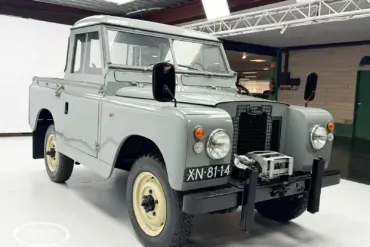 Restaurierter Land Rover Series II Baujahr 1968 mit grauer Lackierung und Kennzeichen XN-81-14, frontal aufgenommen in einer Ausstellungshalle.