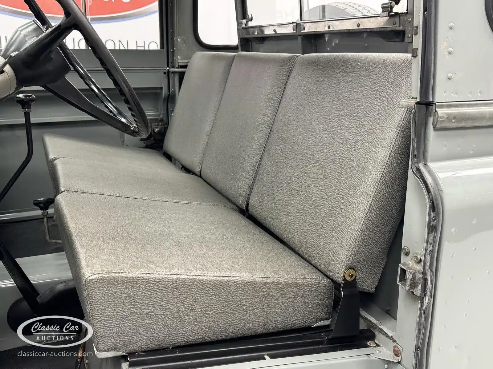 Innenansicht eines Land Rover Series II von 1968 mit grauer Sitzbank und Lenkrad