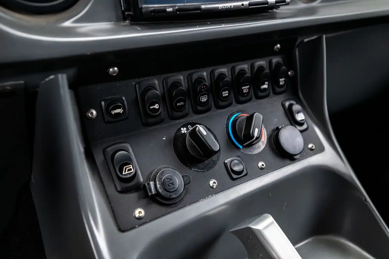 Detailaufnahme der Mittelkonsole mit Schaltern und Drehreglern im Innenraum des Local Motors Rally Fighter