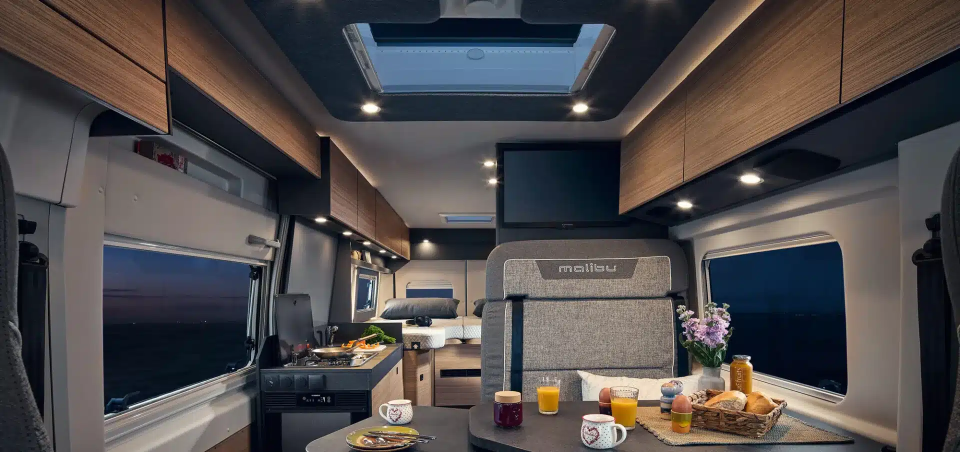 Wohnraum und Innenausstattung des Malibu relax 640 LE R Kastenwagens mit Beleuchtung, Küche und Essbereich.