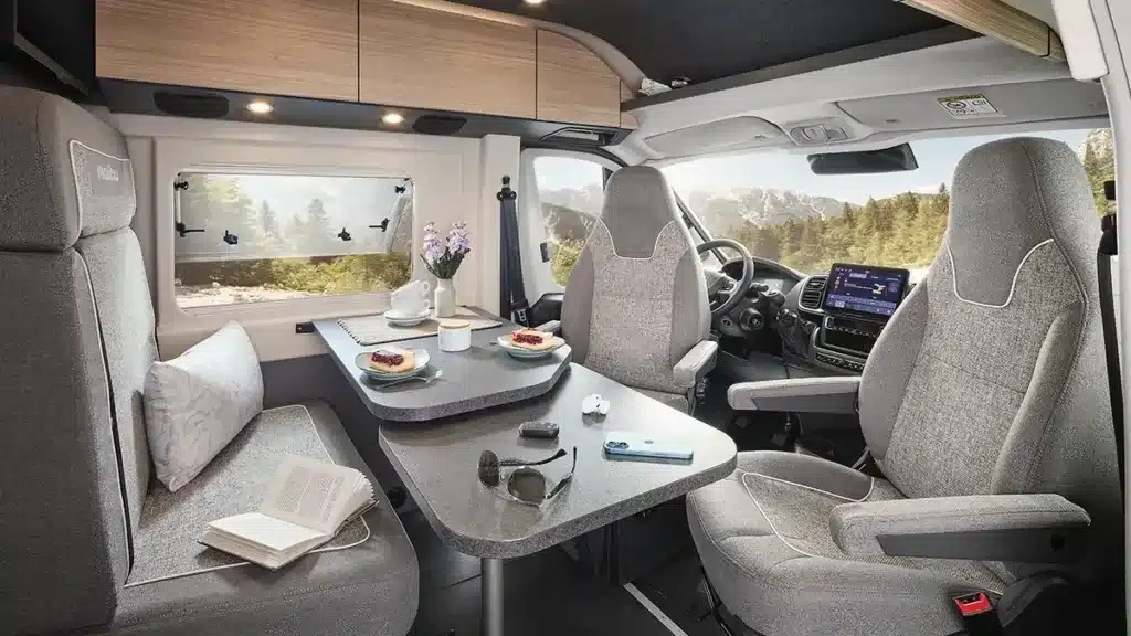 Wohnbereich im Malibu relax 640 LE R mit Tisch, Sitzgruppe und Fahrerhaus, Ausblick auf die Natur