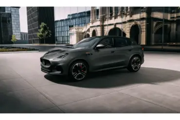 Grauer Maserati Grecale Folgore 2026 vor moderner Glasfassade, seitliche Ansicht.