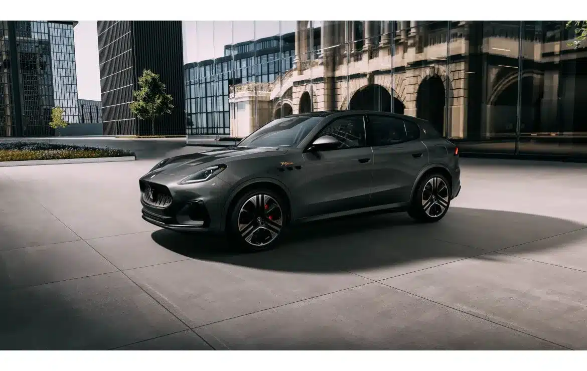 Grauer Maserati Grecale Folgore 2026 vor moderner Glasfassade, seitliche Ansicht.