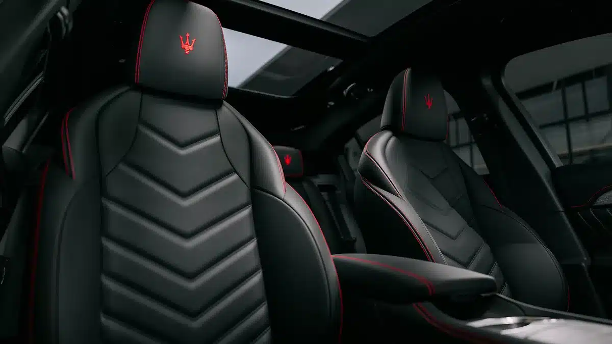 Sportsitze aus schwarzem Leder mit roter Ziernaht und roten Maserati-Logos im Innenraum eines Maserati Grecale Folgore