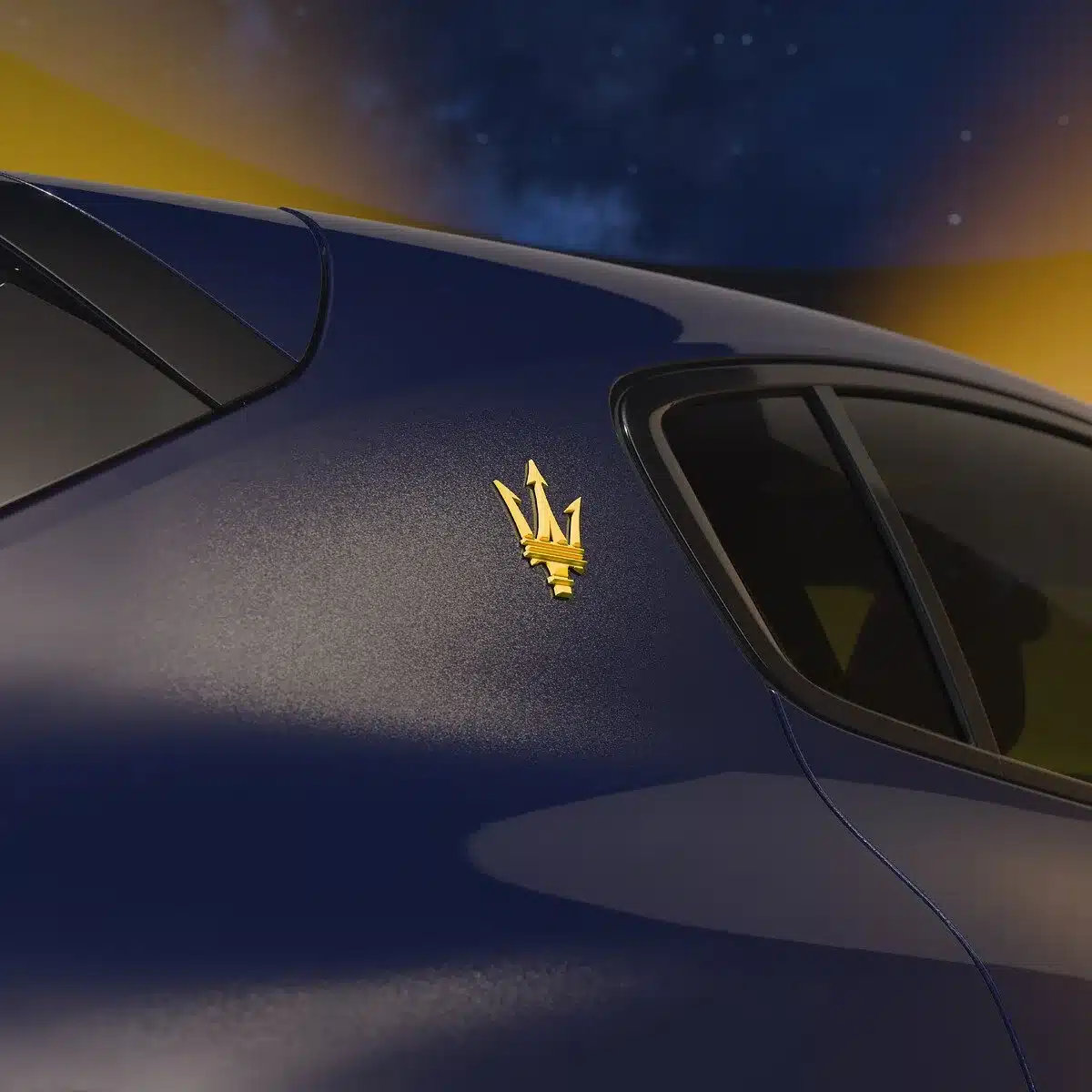 Gelbes Maserati-Trident-Logo an der C-Säule eines blauen Grecale Lumina Blu Sondermodells vor Nachthimmel.