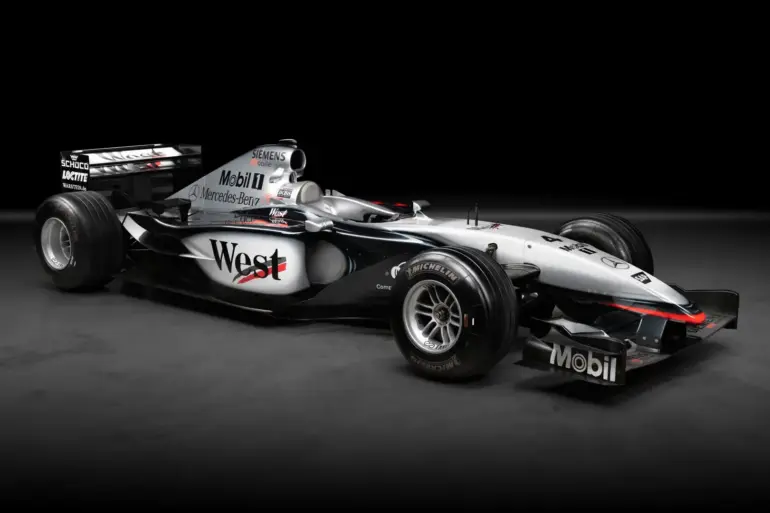 Seitenansicht des McLaren MP4-17A Formel-1-Autos mit West-McLaren-Mercedes-Lackierung auf schwarzem Hintergrund.