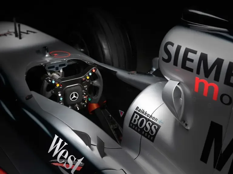 Cockpitansicht eines McLaren MP4-17A Formel-1-Autos mit Lenkrad und Sponsorenlogos von West, Siemens, Hugo Boss und Mercedes-Benz.