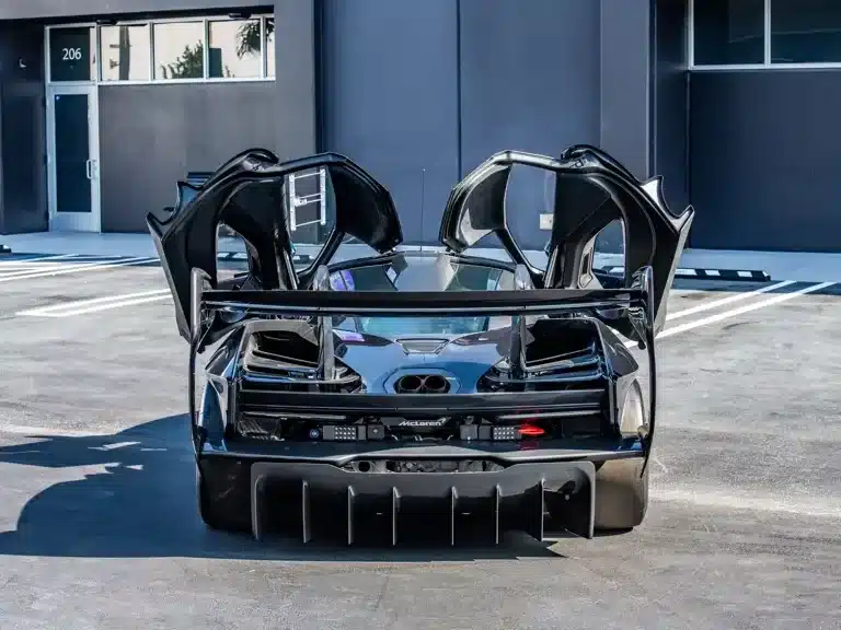 Rückansicht eines McLaren Senna GTR mit geöffneten Flügeltüren, Fokus auf Heckflügel und Diffusor.