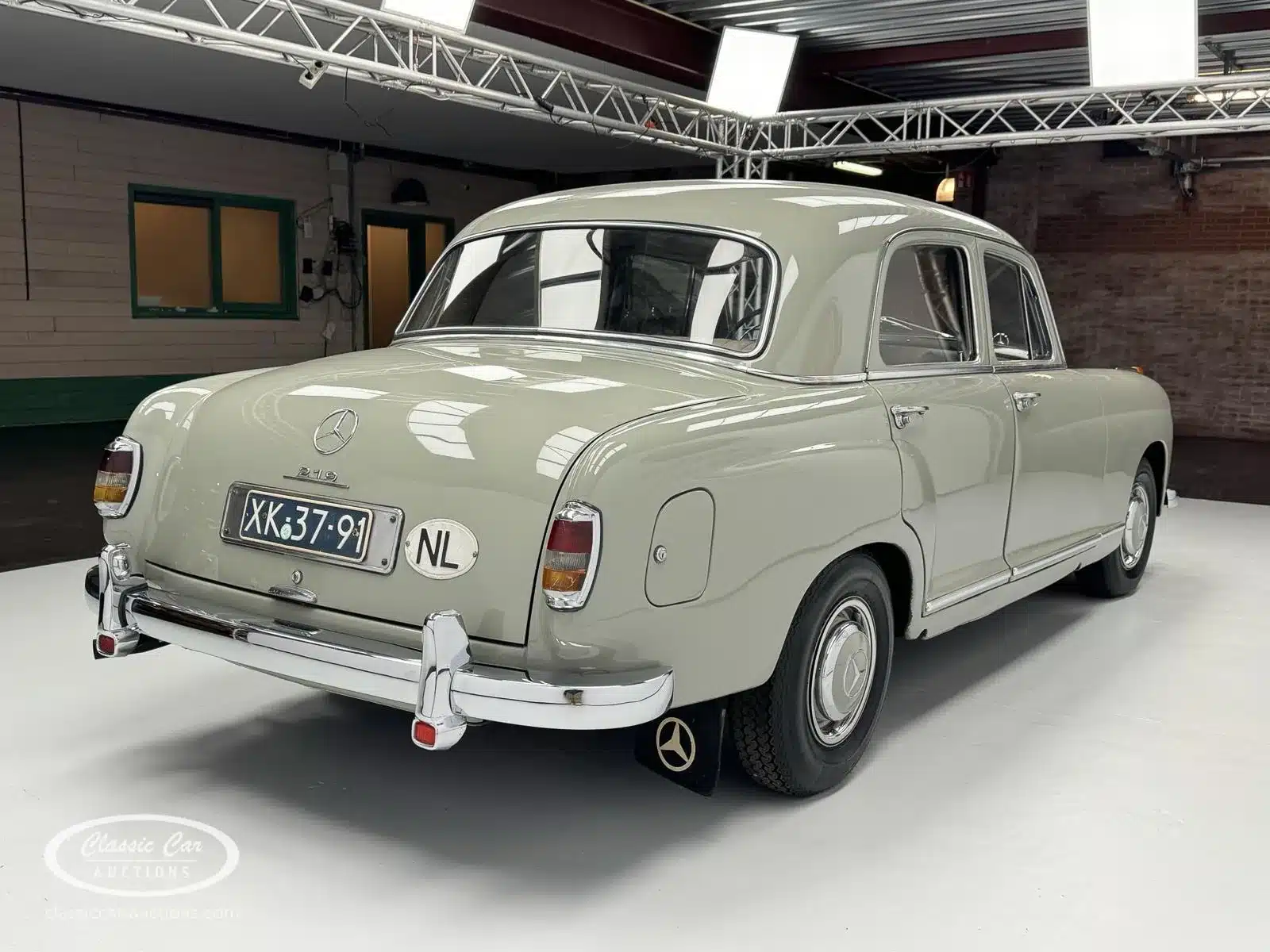 Mercedes-Benz 219 S (Baujahr 1957) in heller Farbe, fotografiert von hinten in einer Indoor-Halle