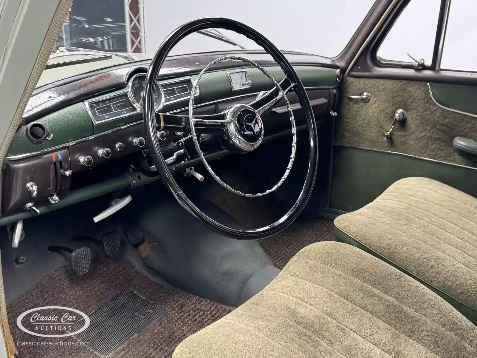 Armaturenbrett und Interieur eines Mercedes-Benz 219 S, Baujahr 1957, mit Lenkrad, Holzzier und Bedienelementen.