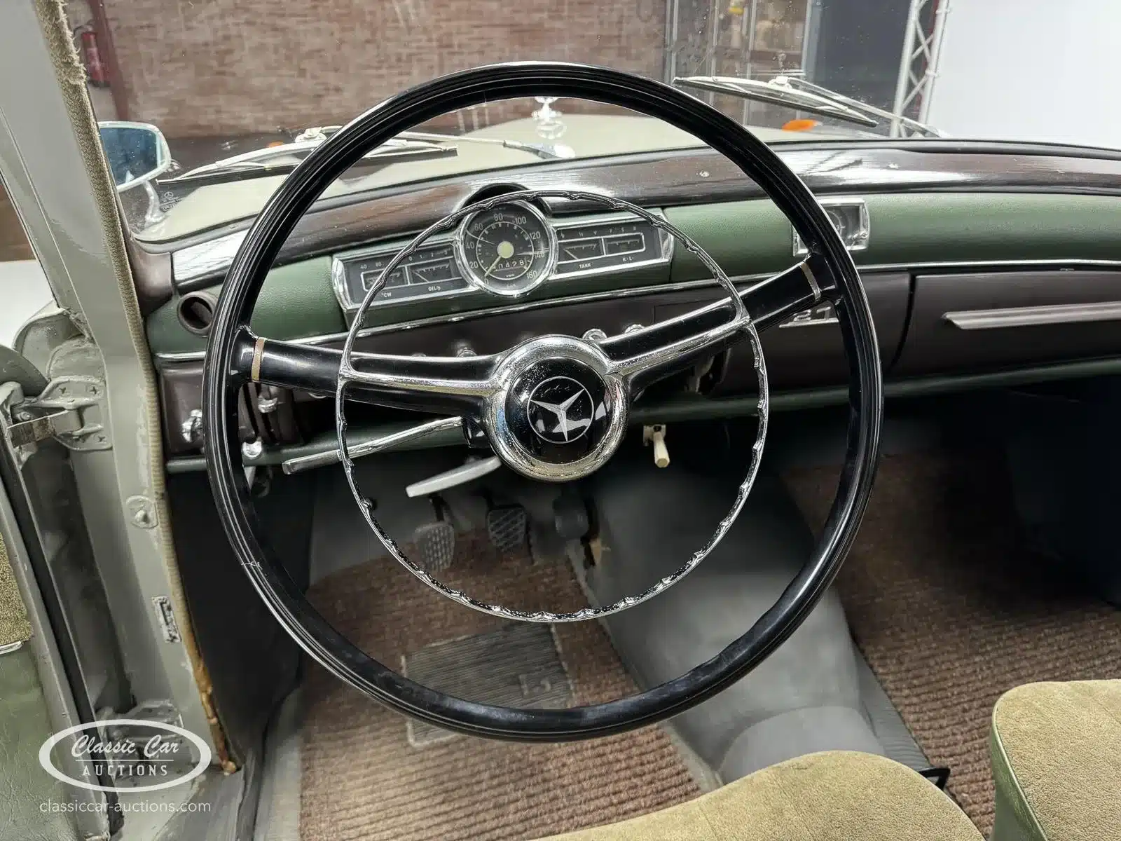 Innenraum mit Lenkrad und Armaturenbrett eines Mercedes-Benz 219 S von 1957, gut erhalten.