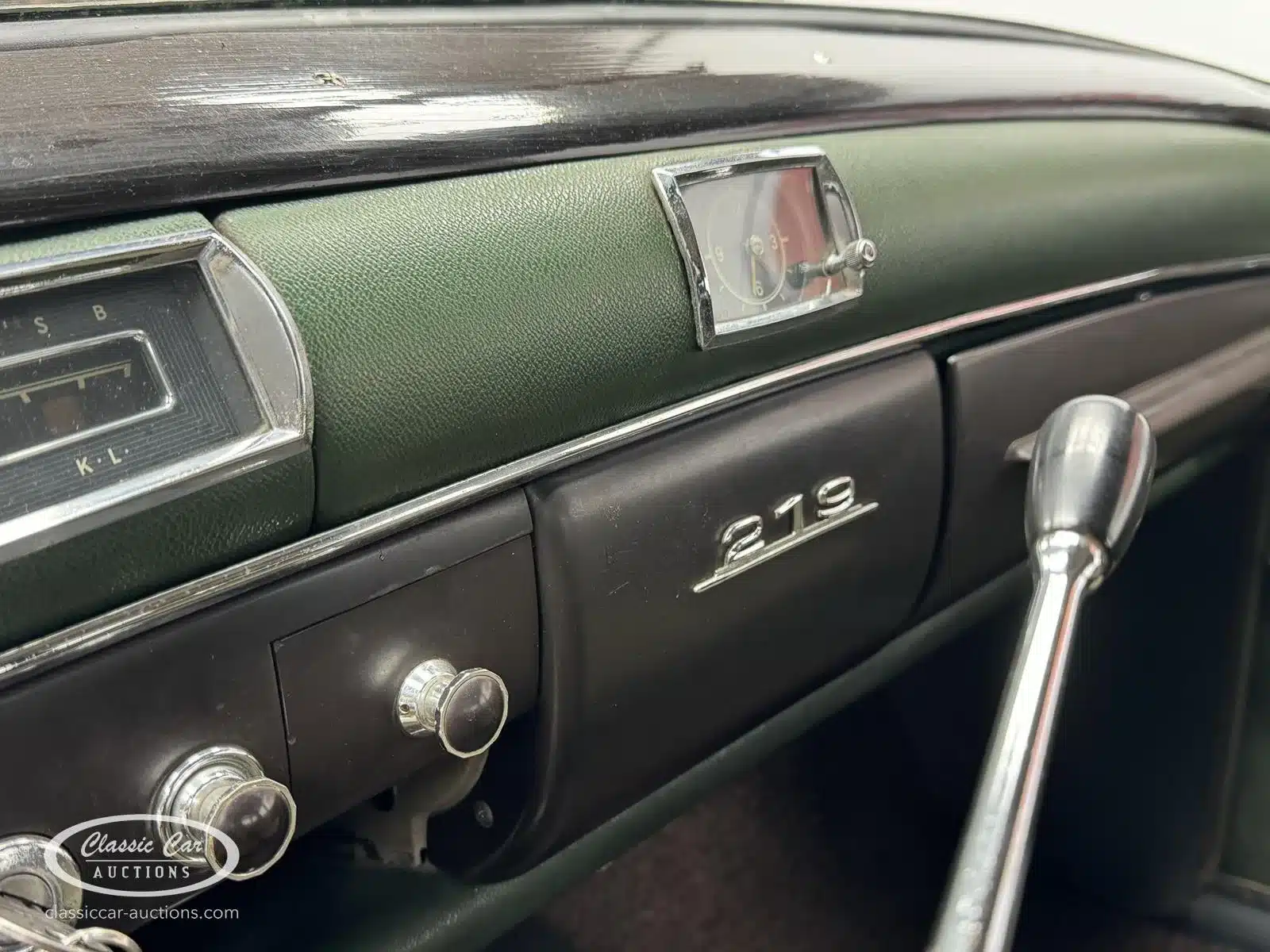 Innenraum des Mercedes-Benz 219 S von 1957 mit Armaturenbrett-Detail, Emblem und Uhr.