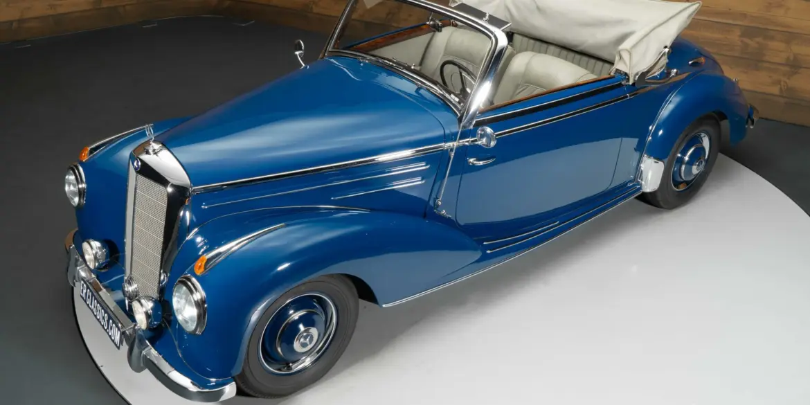 Blaues Mercedes-Benz 220 A Cabriolet aus dem Jahr 1951 mit beigem Verdeck und Chromdetails