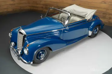 Blaues Mercedes-Benz 220 A Cabriolet aus dem Jahr 1951 mit beigem Verdeck und Chromdetails