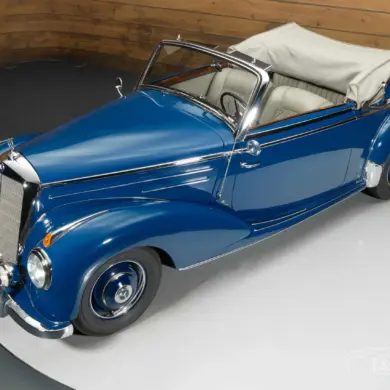 Blaues Mercedes-Benz 220 A Cabriolet aus dem Jahr 1951 mit beigem Verdeck und Chromdetails