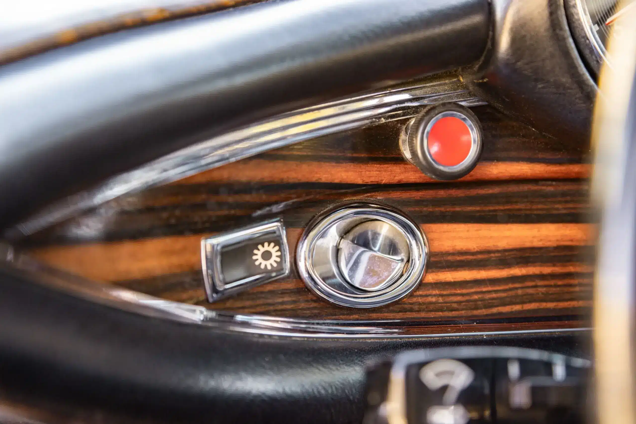 Detailaufnahme des Armaturenbretts mit Schalter, Drehknopf und Holzfurnier im Mercedes-Benz 280SE W111 Coupé