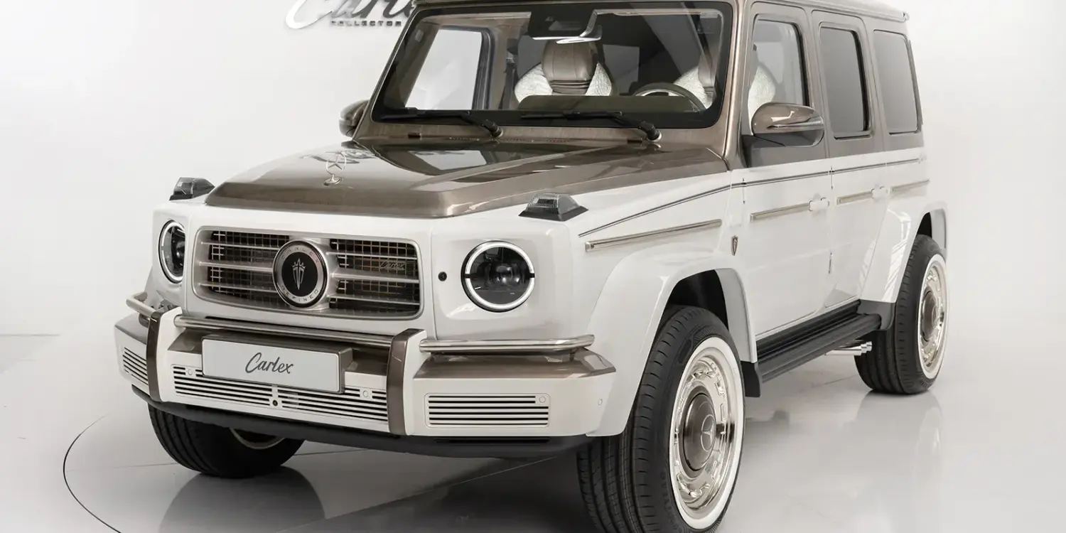 Mercedes-Benz G63 AMG Himalaya mit pastellweißer und goldener Diamantlackierung seitlich frontal im Studio