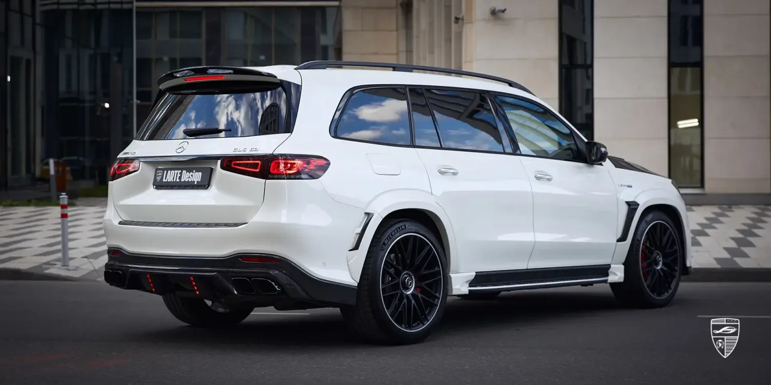 Heckansicht eines weißen Mercedes-Benz GLS 63 AMG (X167) mit LARTE Design Bodykit und auffälligen Sportfelgen.