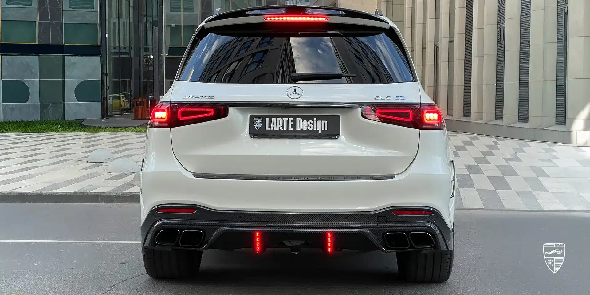 Heckansicht eines weißen Mercedes-Benz GLS 63 AMG X167 mit LARTE Design Winner Edition Bodykit und beleuchtetem LARTE-Logo.