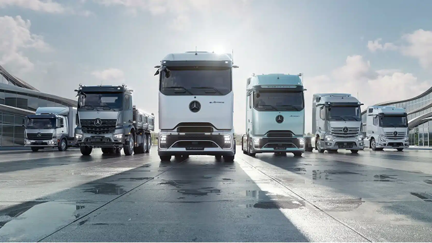 Reihe verschiedener Mercedes eActros Elektro-Lkw auf einem großen, modernen Gelände