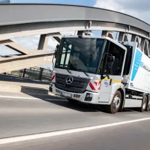 Elektrischer Lkw Mercedes-Benz eEconic fährt über eine Brücke in einer urbanen Umgebung.