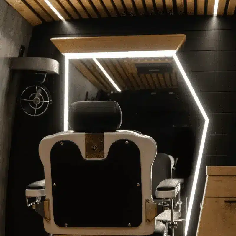 Barberstuhl vor beleuchtetem Spiegel im mobilen Barbershop auf Basis eines Mercedes Sprinter