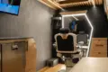 Innenraum eines umgebauten Mercedes Sprinter als mobiler Barbershop mit Barberstuhl, großem Spiegel, TV und moderner Ausstattung.